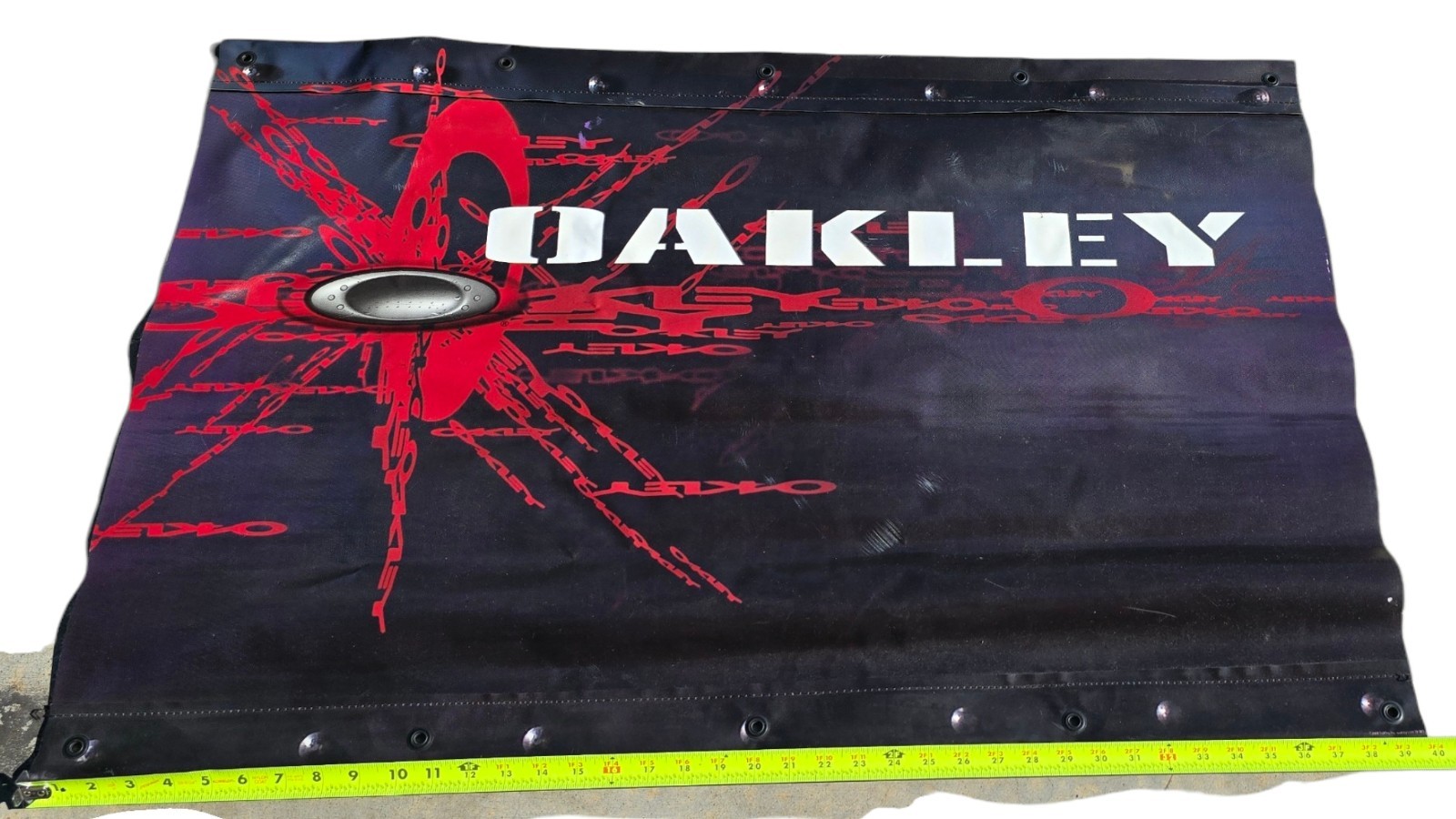 2004 Vinyl Oakley Advertising Banner Sign Two Sided Black & Red 39.75″ x 25.5″