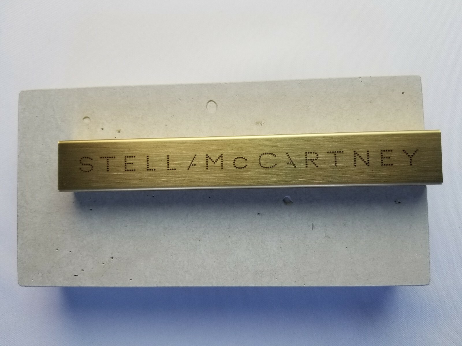STELLA McCARTNEY GRAY MARBLE LOGO PLAQUE IN STONE & GOLD METAL