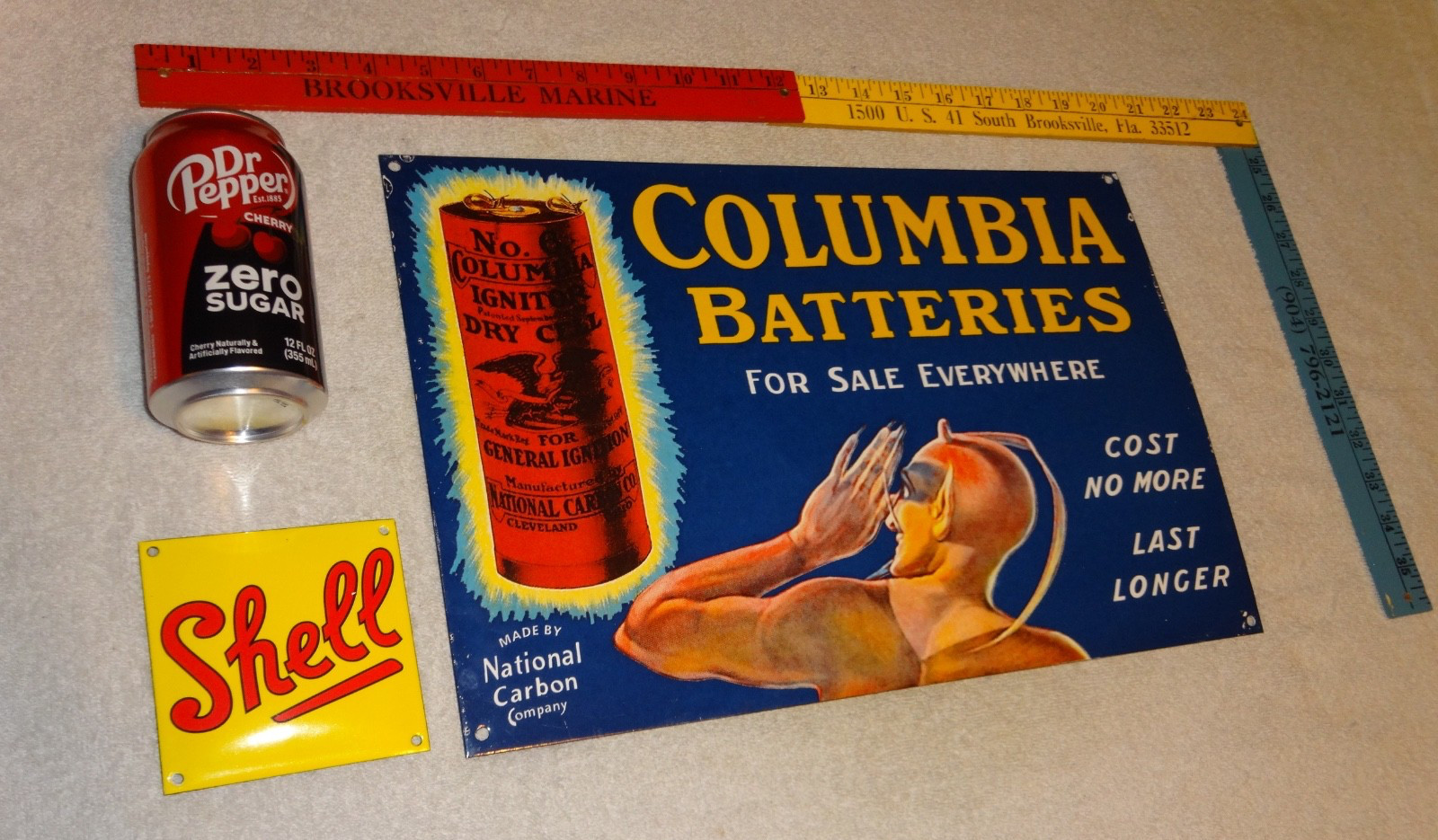 VINTAGE COLUMBIA DRY CELL BATTERIES +DEVIL 16″ PORCELAIN METAL GASOLINE OIL SIGN