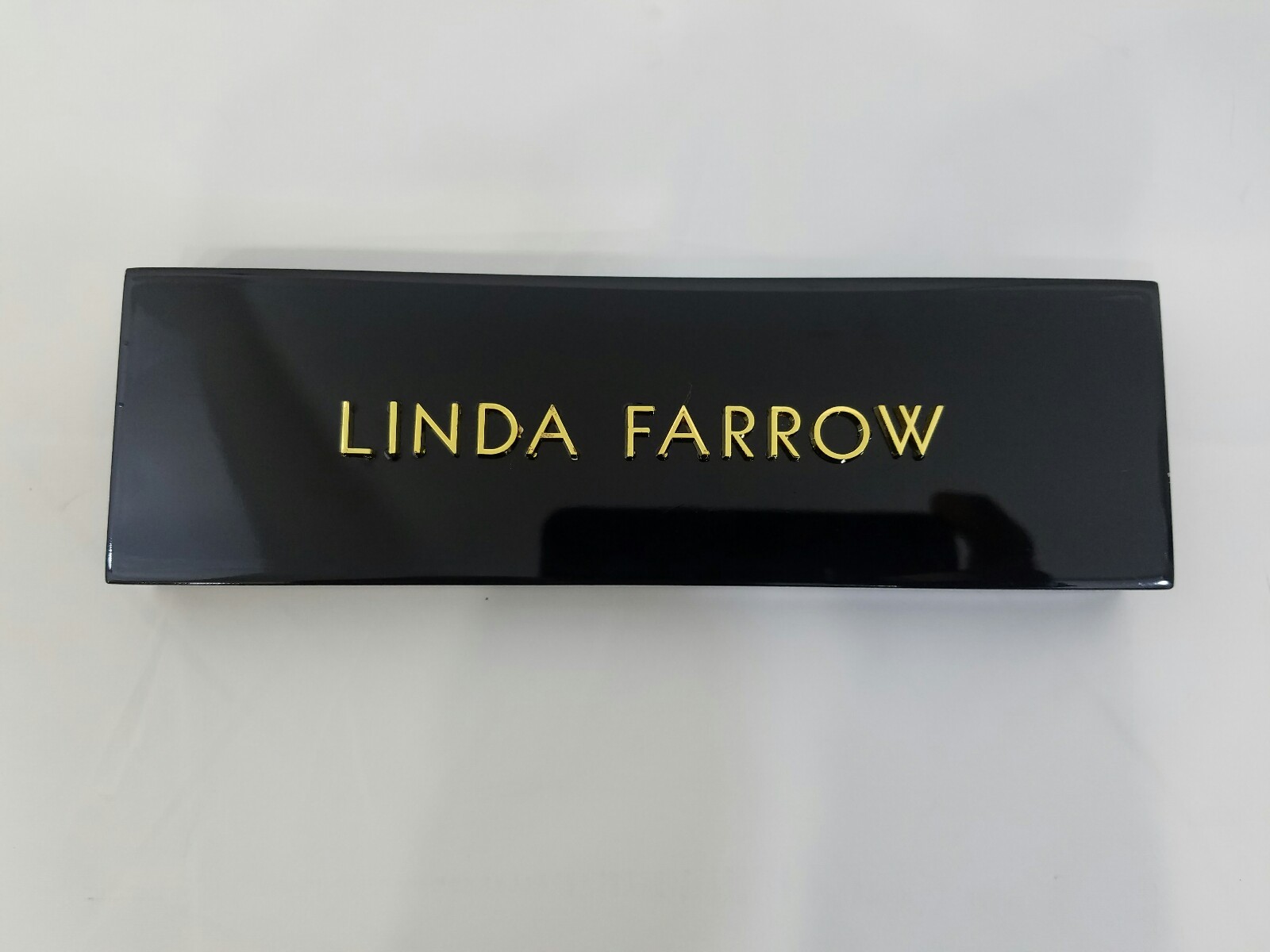 LINDA FARROW LOGO SHINY BLACK PLAQUE WITH GOLD LETTERING W/ REVO ADVERT PLAGUE